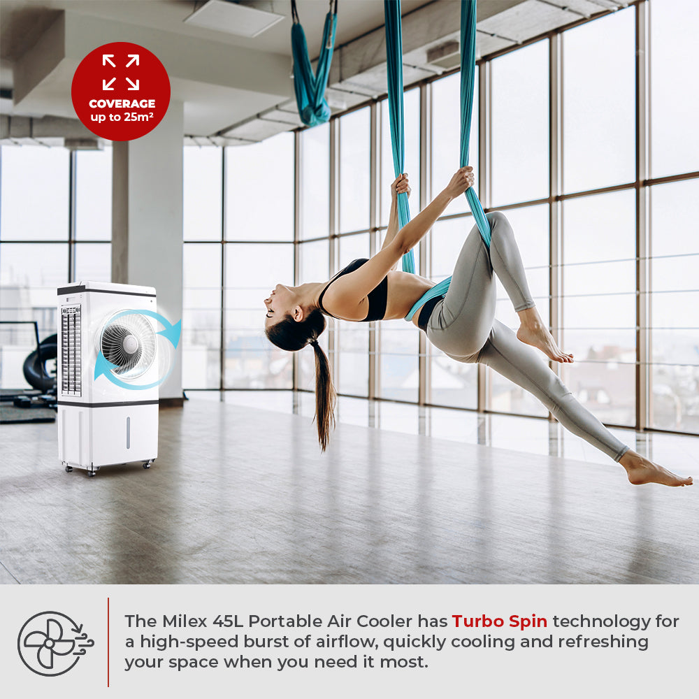 Woman practicing aerial yoga in a modern indoor setting with a Milex portable air cooler.